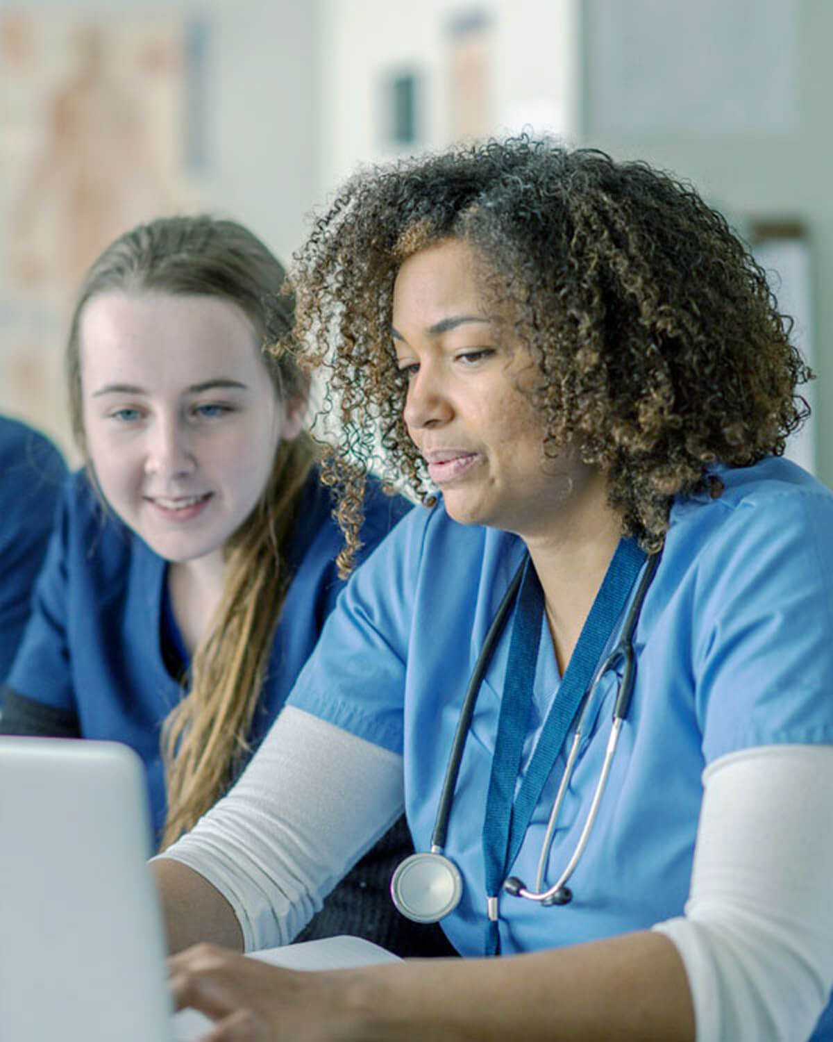 two nurses looking at a laptop